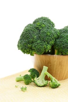 Fresh Broccoli in a wooden bowl on a table cloth