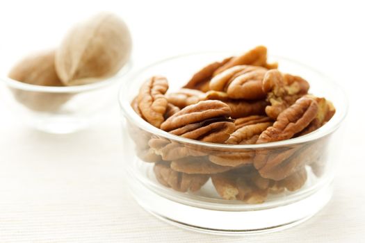 Pecan nuts in glass containers on white table cloth