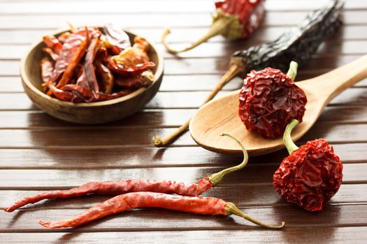 Assortment of dried chili peppers  on wooden matt
