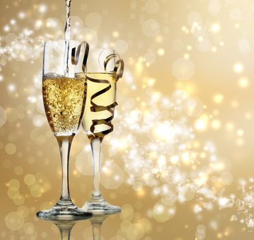 Two champagne flutes on gold shiny background