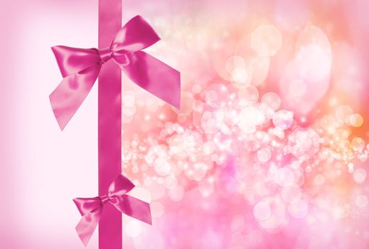 Pink Bow and Ribbon with Pink Abstract Lights Background 