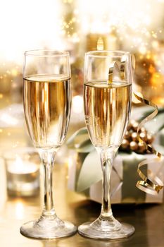 Shining champagne glasses with candles and gifts 