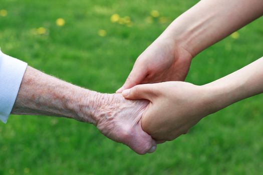 Senior and Young Women Holding Hands Outside