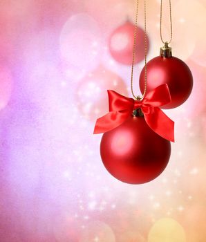 Christmas red ornaments over pink  lights background