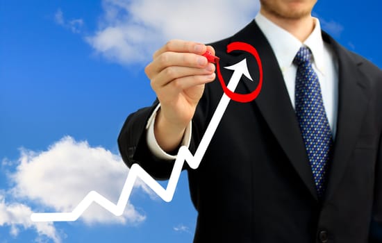 Businessman circling a rising arrow on a graph (representing growth)