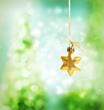 Christmas star ornament over green tree lights background