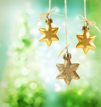 Christmas star ornaments over green tree lights background