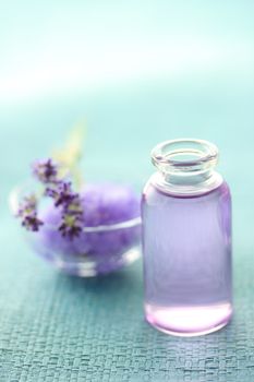 Aromatherapy oil and lavender with bath salt over blue background