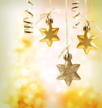 Christmas star ornaments over yellow orange lights background