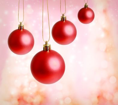 Red christmas ornaments with pink lights background