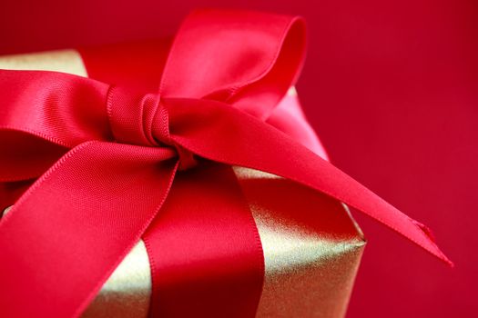 Gift box with red ribbon on red background