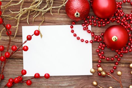 Red Christmas ornaments on wood with note card