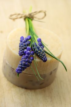 Handmade soap and muscari flowers on wooden board