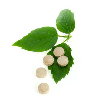 Natural pills with green leaves
