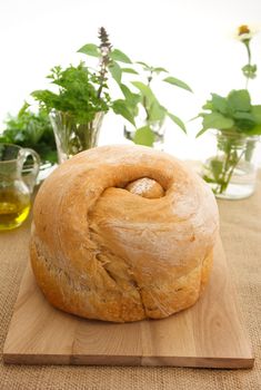 Loaf of bread with collection of herbs