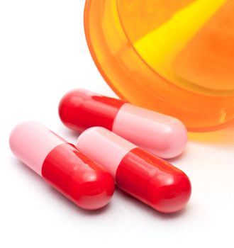 Red and pink capsules on white background