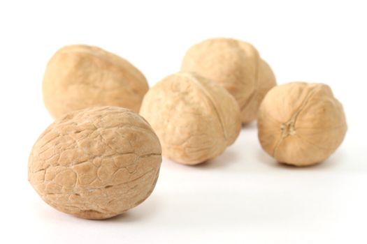 Five walnuts in shells isolated on white background
