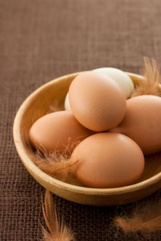 Fresh chicken eggs in wooden bowl