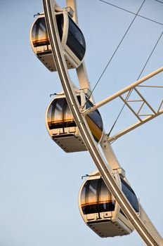 White ferris wheel at sunset with reflection in the mirror.