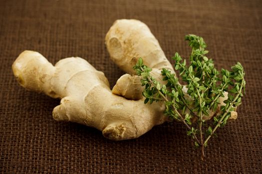 Ginger and thyme on brown cloth