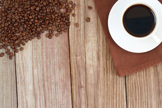 Cup of coffee with coffee beans on wooden table