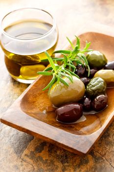 Olive oil and mixed olives with fresh rosemary