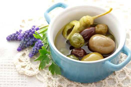 Olives in little pot on white table cloth