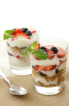 Vanilla yogurt over strawberries, blueberries and lemon balm