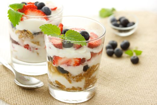 Vanilla yogurt over strawberries, blueberries and lemon balm
