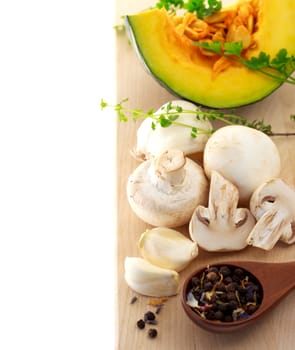Mushrooms and kabocha pumpkin with spices and herbs on cutting board