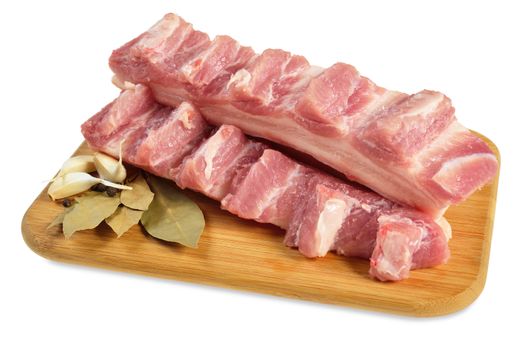 Raw bacon with ribs on a wooden cutting board. Isolated on white.