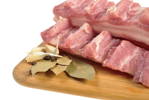 Raw bacon with ribs on a wooden cutting board. Isolated on white.
