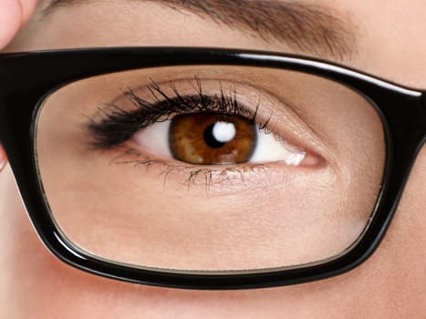 Glasses eyewear closeup. Macro of woman black eye wear glasses frame. Brown eyes of multiethnic Chinese Asian / Caucasian woman model.