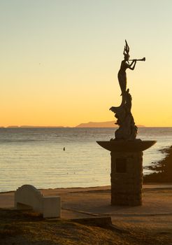 Mermaid statue playing flute by unknown artist at entrance to Ventura Harbor