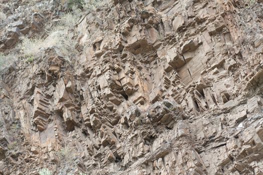 Closeup of the textured rocky vertical slope of a mountain in Spain.