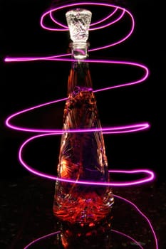 Crystal Bottle Lit Up with Purple Light Trails