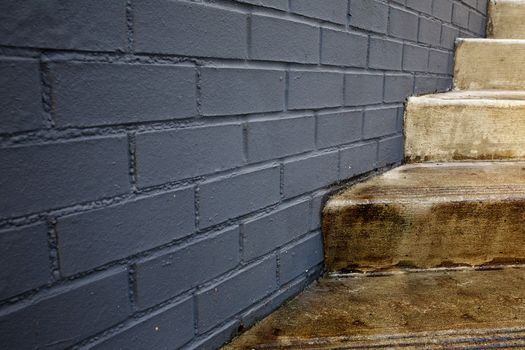Abstract of concrete outdoor stair case intersecting gray block wall