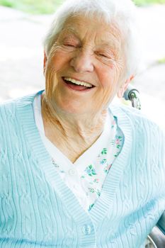 Happy senior lady in wheelchair in spring day