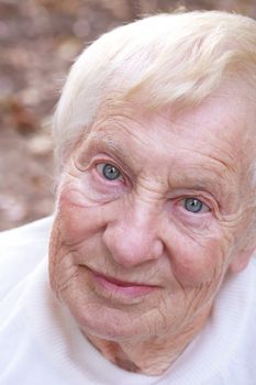 Happy senior lady smiling outside in autumn