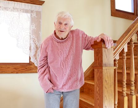 Senior lady smiling in front of staircase