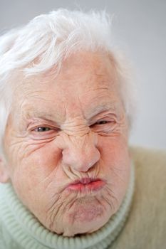 Close up image of senior woman grimacing