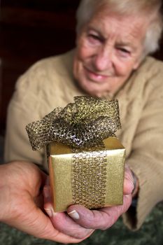 Senior and young women holding a gold gift box