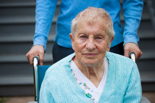 Senior lady in wheelchair with caretaker