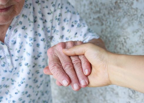 Young holding senior lady's hand