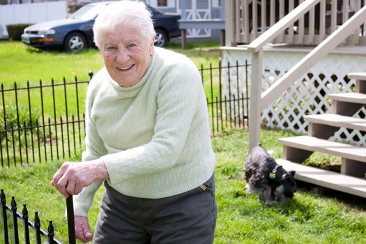 Happy senior lady in backyard with her dog