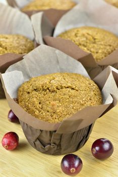 Close-up of freshly baked bran and cranberry muffins on a wooden tray