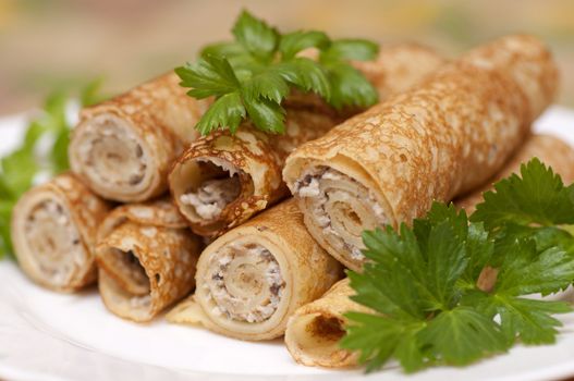 Pancake rolls with chicken and mushrooms on white plate