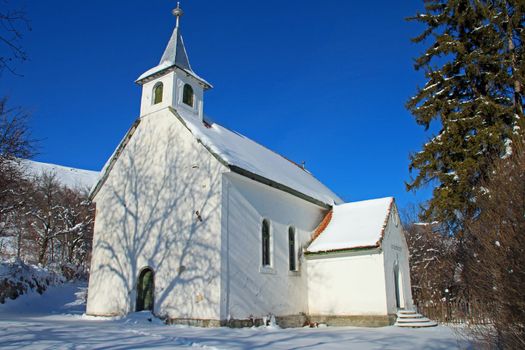 Little white church standing in the winter sunshine