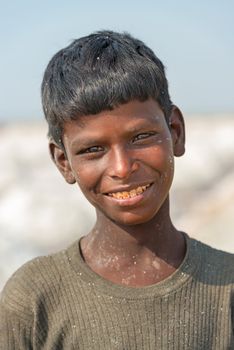 Sambhar, India - Nov 19: Portrait of indian kid in salt farm on Nov 19, 2012 in Sambhar Salt Lake, India. It is India's largest saline lake and where salt has been farmed for a thousand years. 