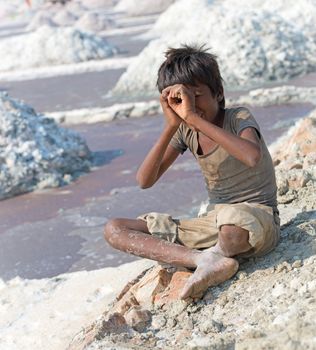 Sambhar, India - Nov 19: Portrait of indian kid in salt farm on Nov 19, 2012 in Sambhar Salt Lake, India. It is India's largest saline lake and where salt has been farmed for a thousand years. 